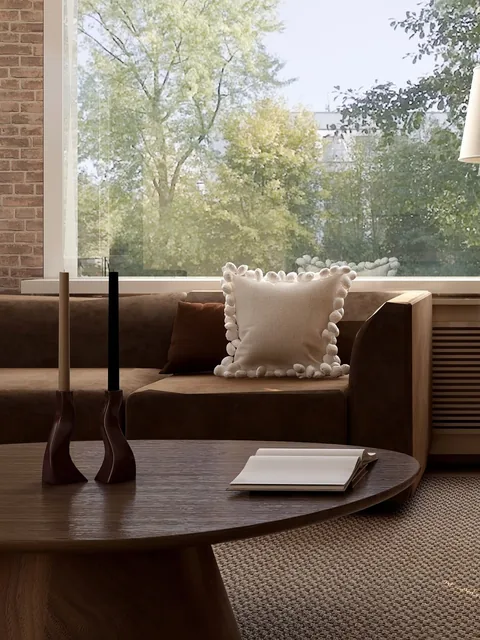 Zithoek met houten salontafel, fauteuils en uitzicht op groen door hoge ramen