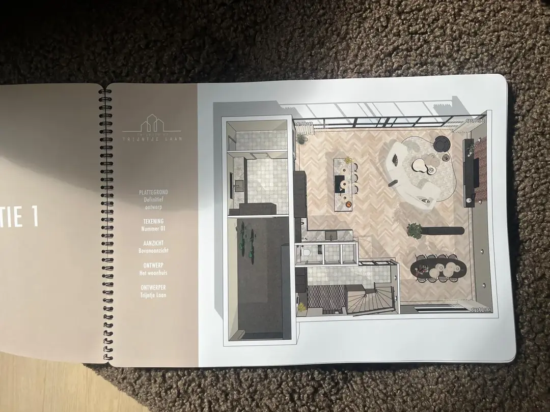 Ontwerpboek open op de 3D plattegrond van het woonhuis met titelblok